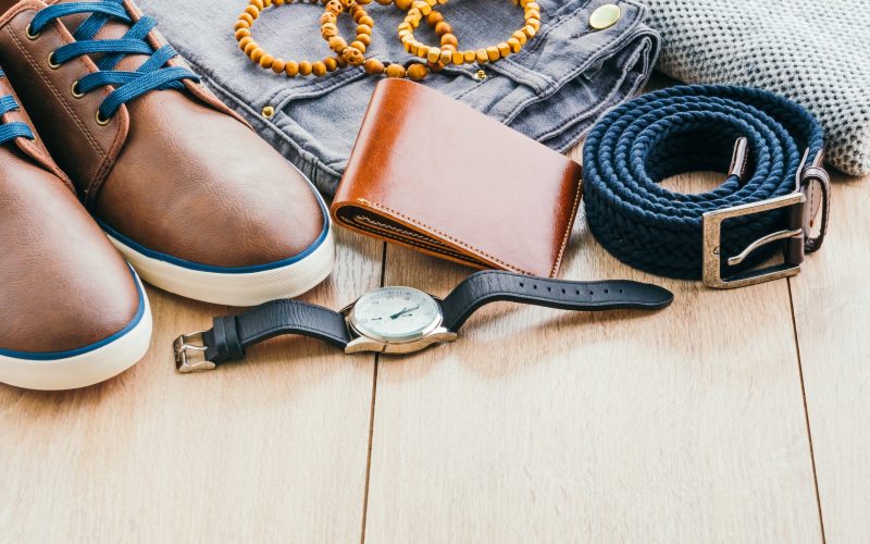 Beautiful men fashion with Sweater Jeans Belt Socks Wallet Watch and Brown leather shoes on wooden background - Vintage light filter Processing